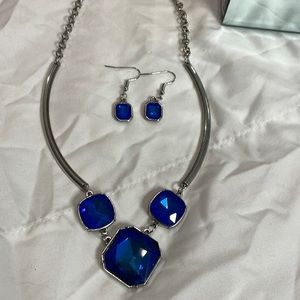 Silver and blue jeweled necklace, bows out and compliments the neckline